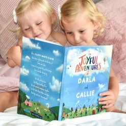 Girls reading their Joyful Adventures personalised book by Tickled Moon