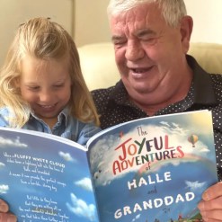 Grandad & granddaughter reading The Joyful Adventurtes by Tickled Moon
