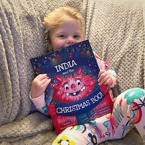 Little girl showing off her personalised book The Christmas BOO