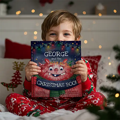 Young boy showing off his personalised book The Christmas BOO