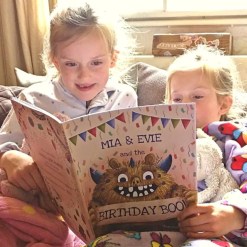 Twin girls reading their unique keepsake personalised book by Tickled Moon