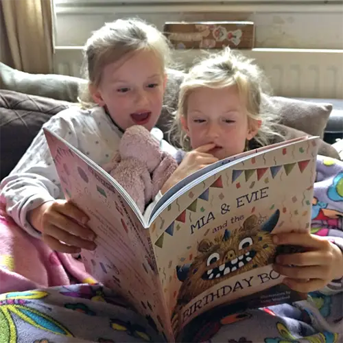 Twin girls reading their personalised book by Tickled Moon